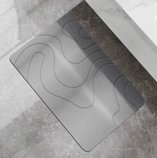 Grey and white diatomite bath mat on a tiled bathroom floor